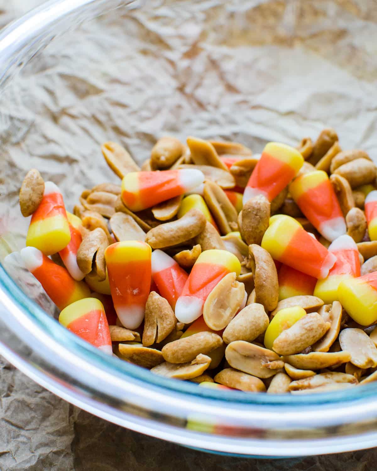 Mixing nuts with candy corn in a bowl.