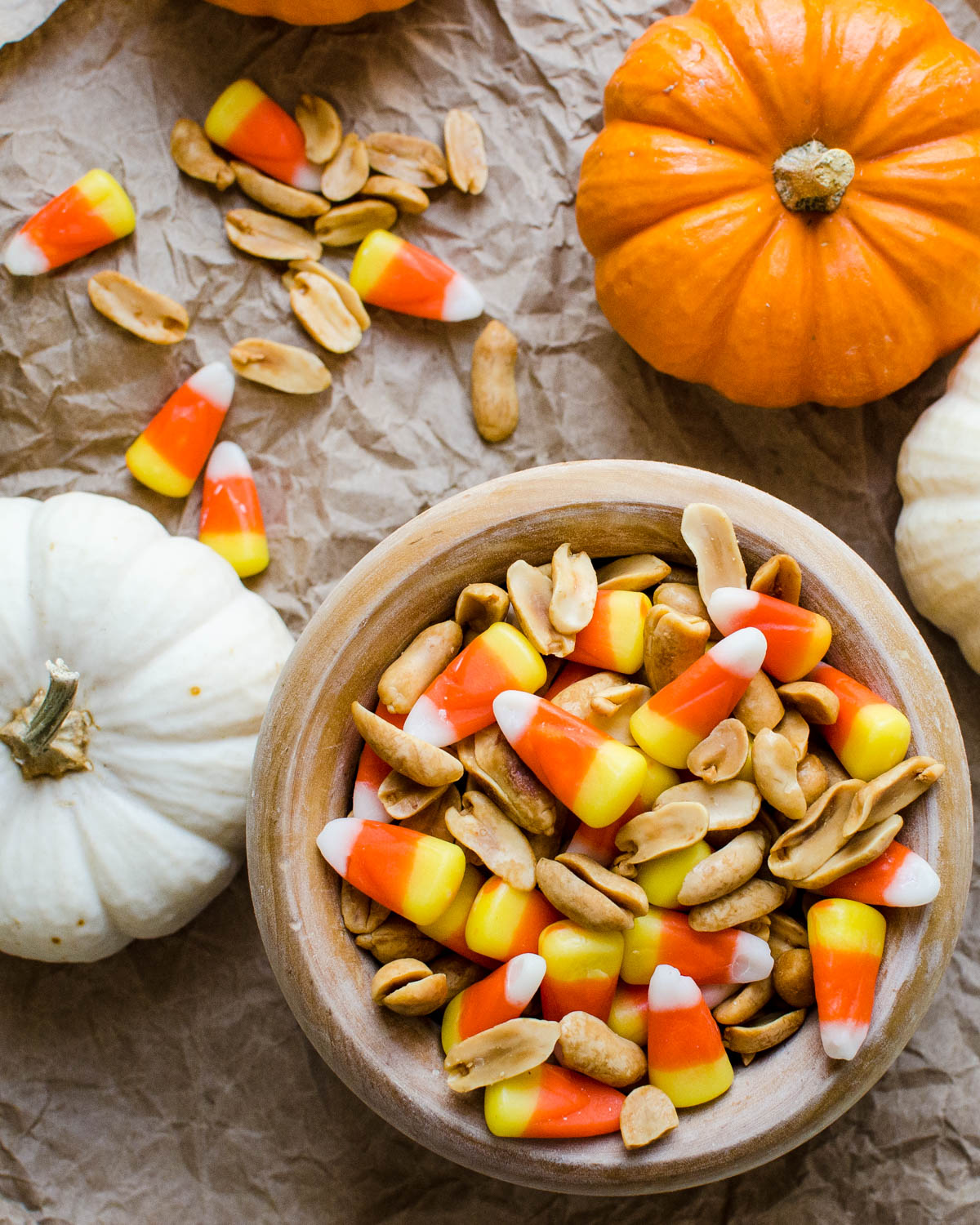 Serving the candy corn and peanuts in a wooden bowl.