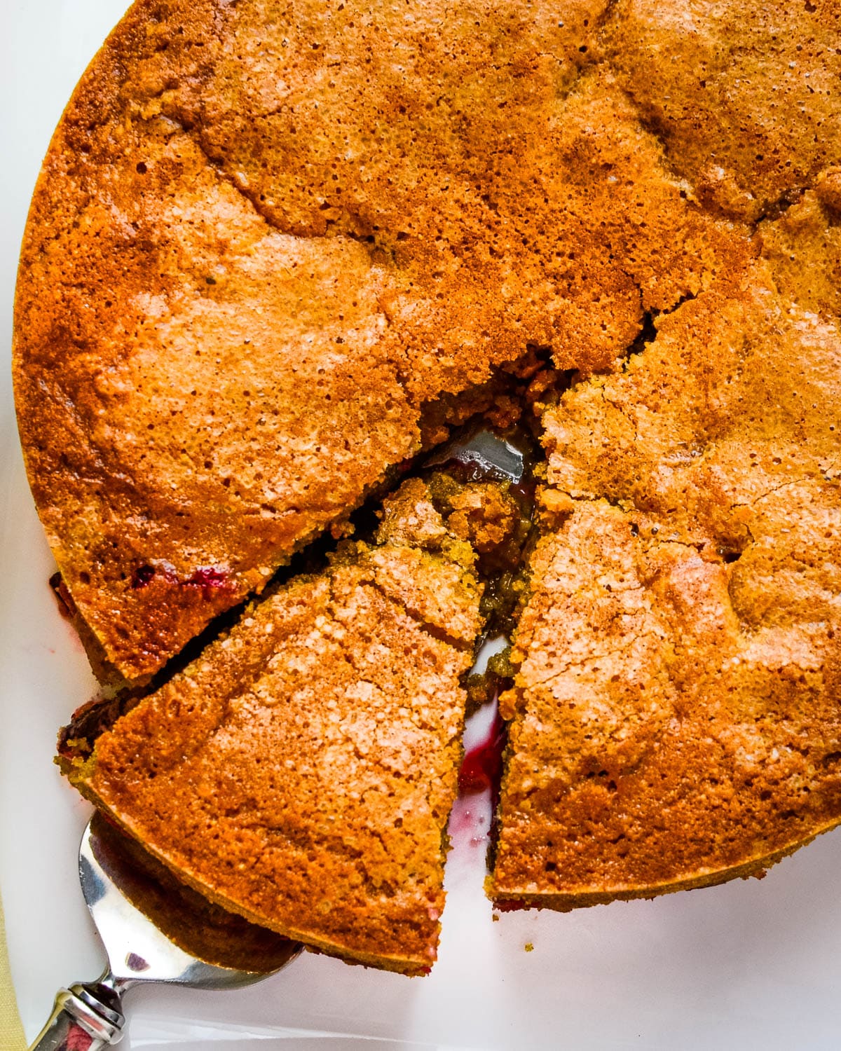 An overhead picture of a slice of cornmeal cake is removed from the whole.
