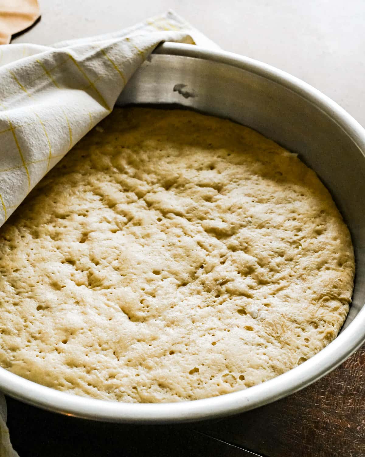 The next day, the dough has spread and risen, filling the bowl with yeast dough.