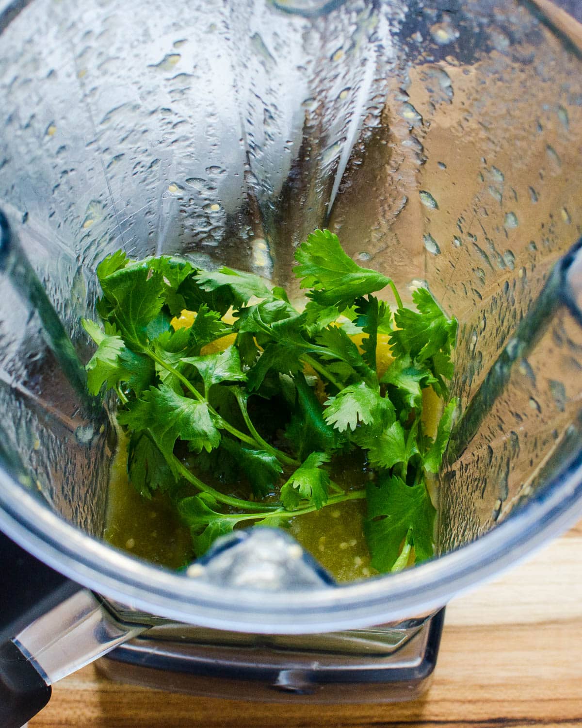 Adding fresh cilantro to the blender. 