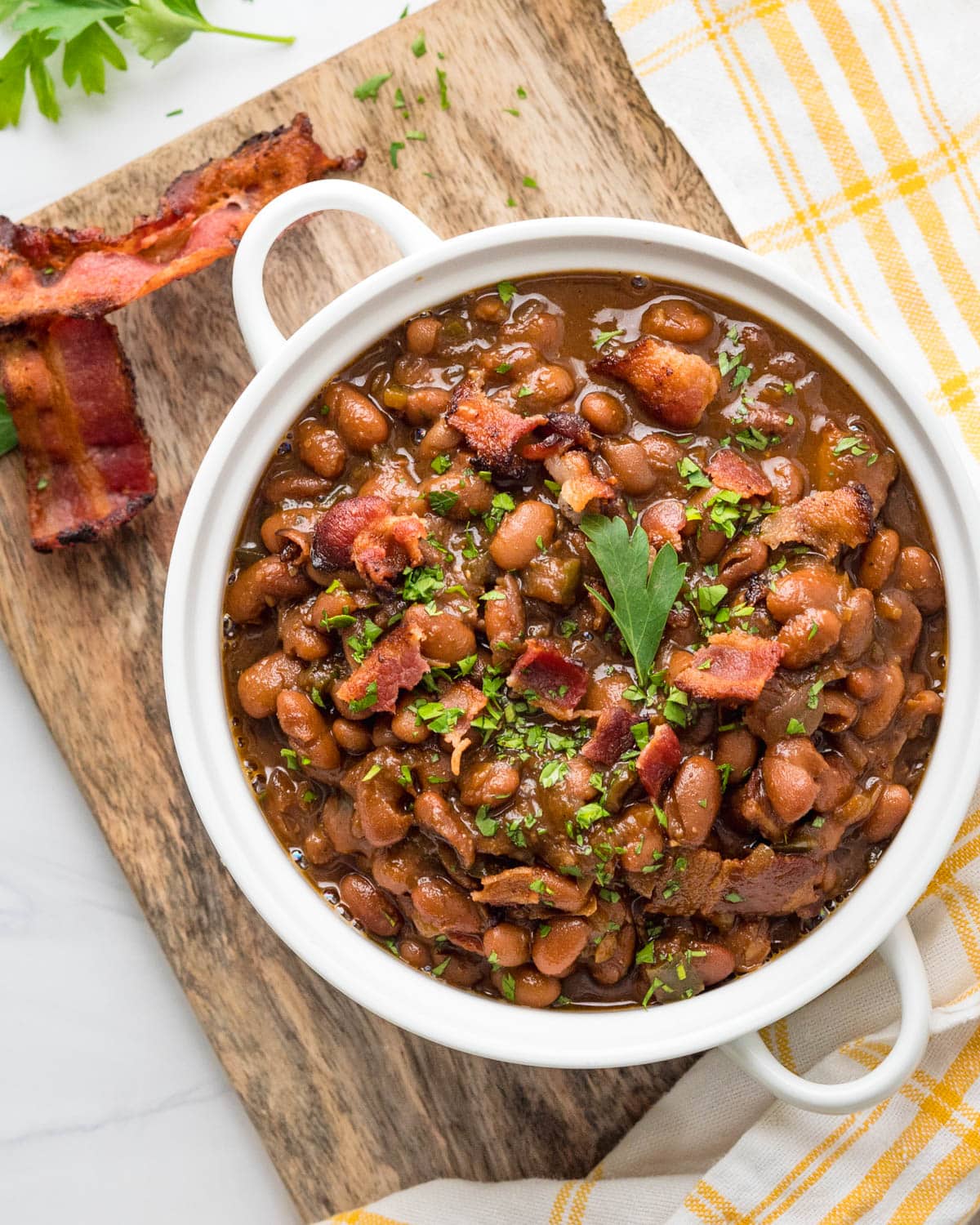 Serving a bowl of baked beans with extra bacon on top.