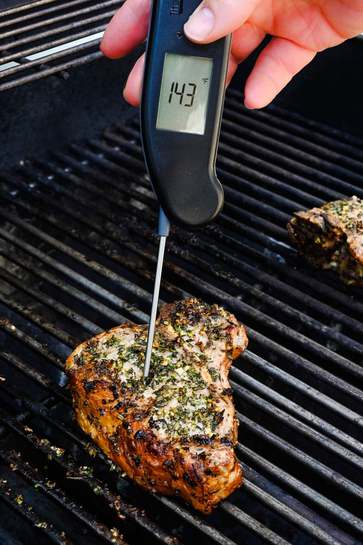 Take the veal chops' temperature as they grill with an Instant read thermometer.