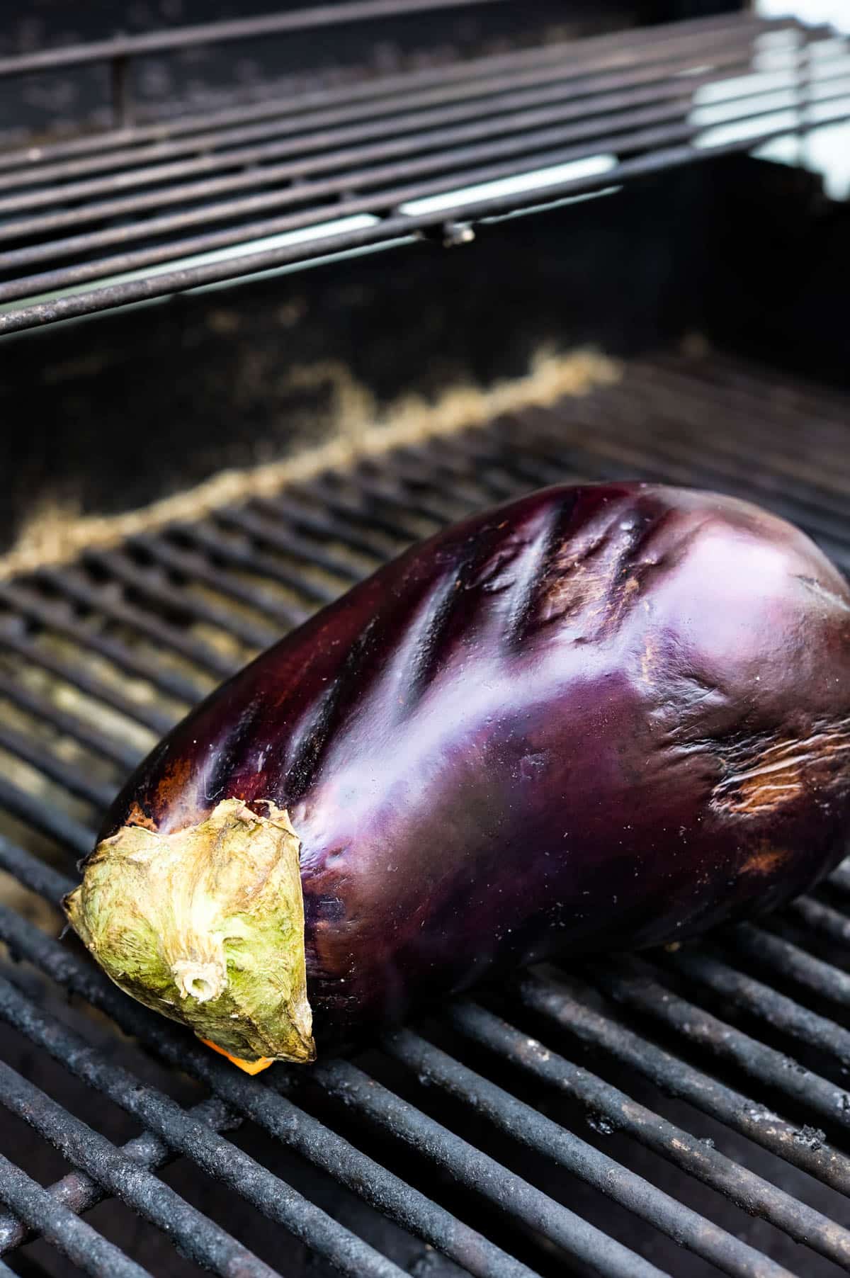 A whole eggplant on a grill.