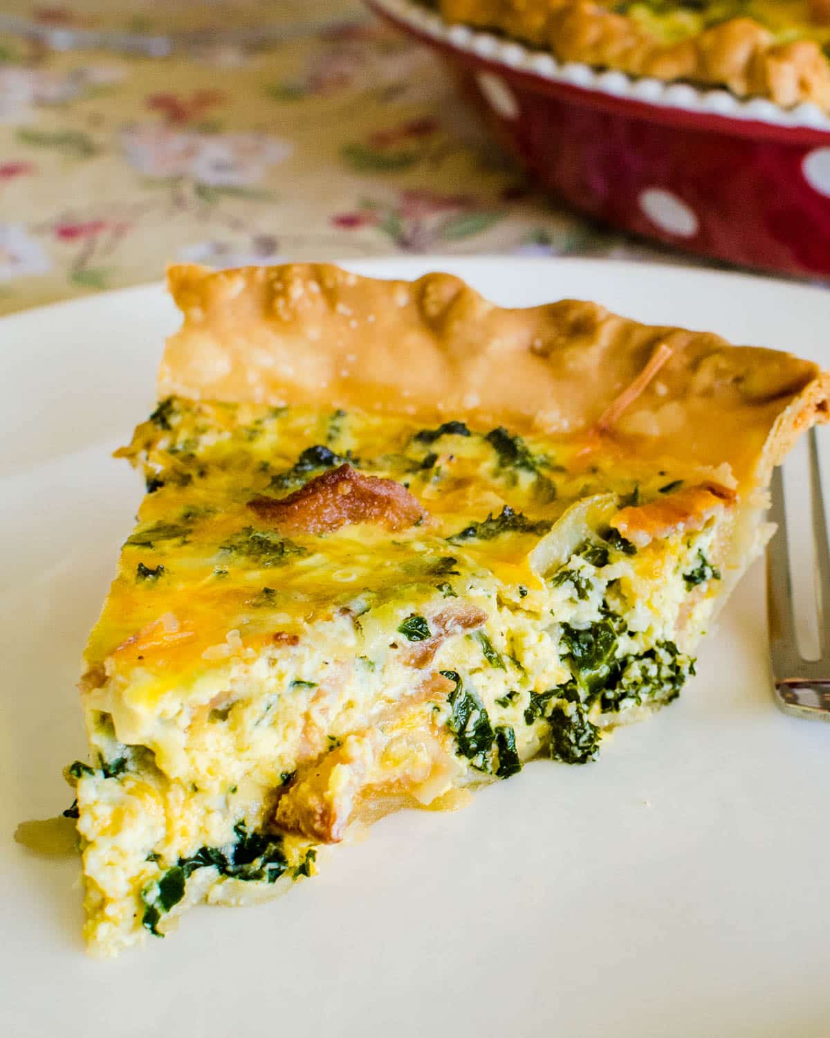 A slice of the bacon cheddar quiche with kale.