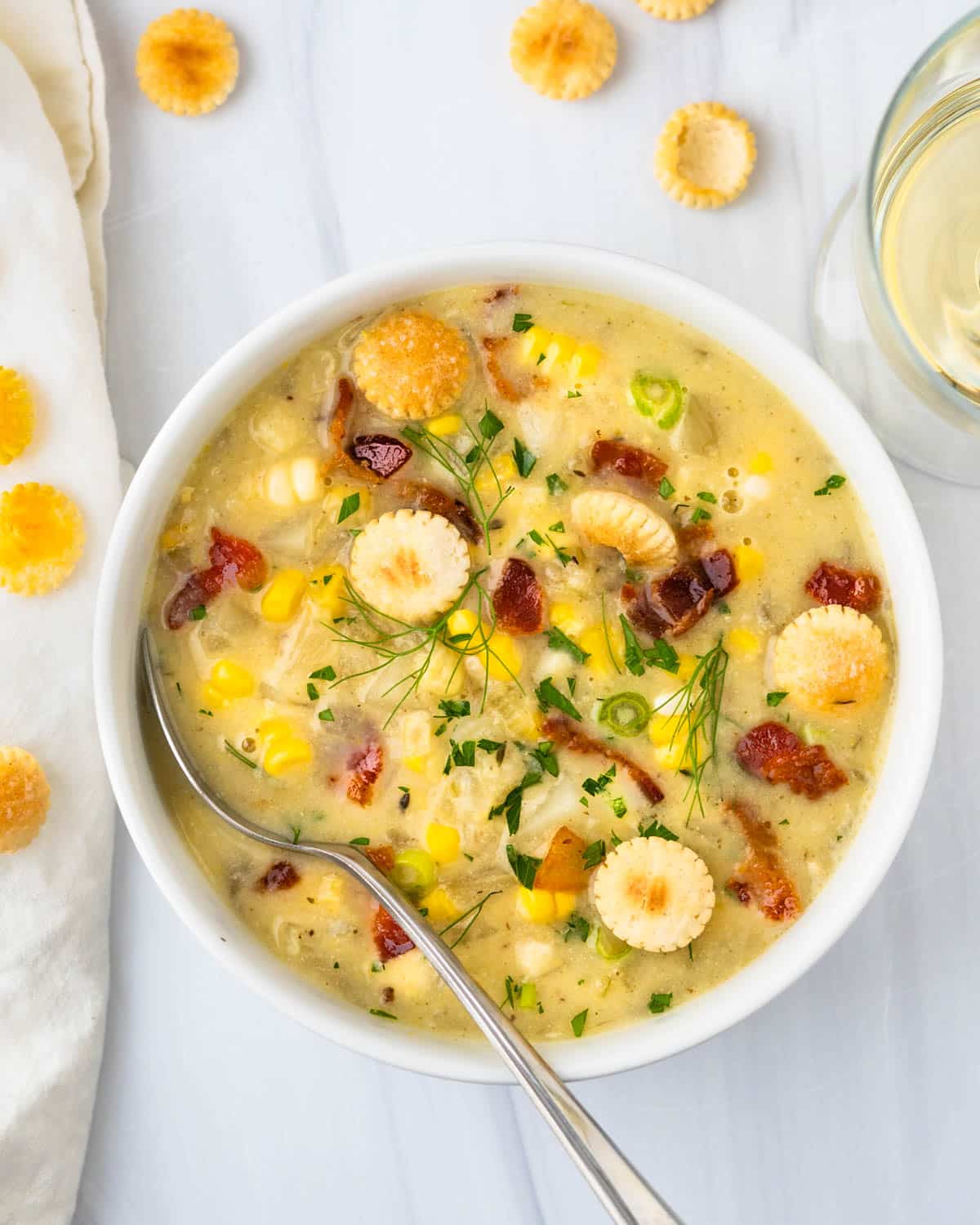 Corn and potato chowder with bacon in a white bowl.