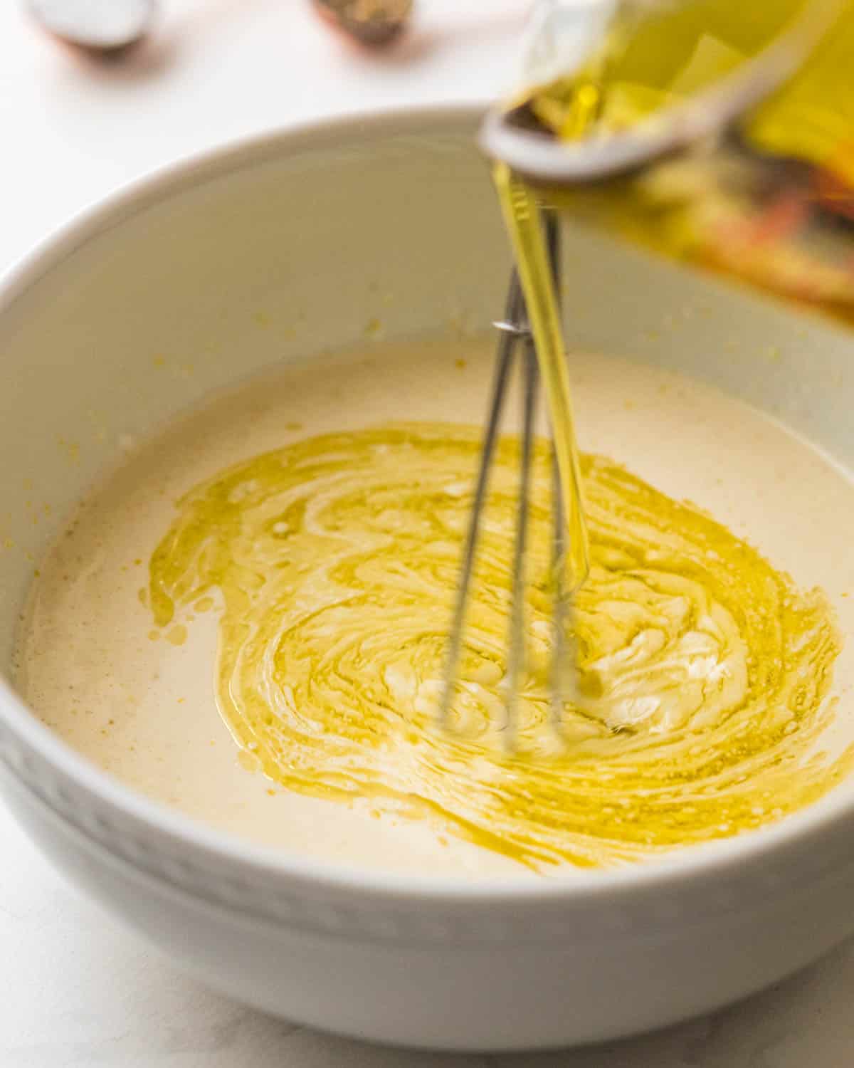 Drizzling in the olive oil to the mayo mixture while whisking.