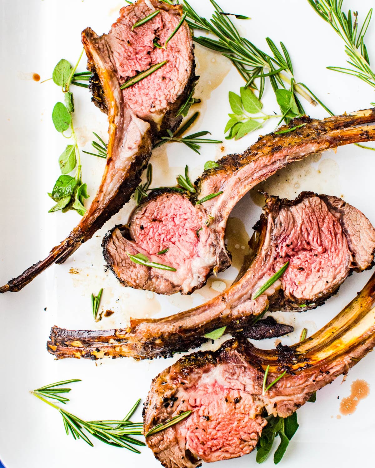 Grilled lamb rack cut into chops on a white platter.