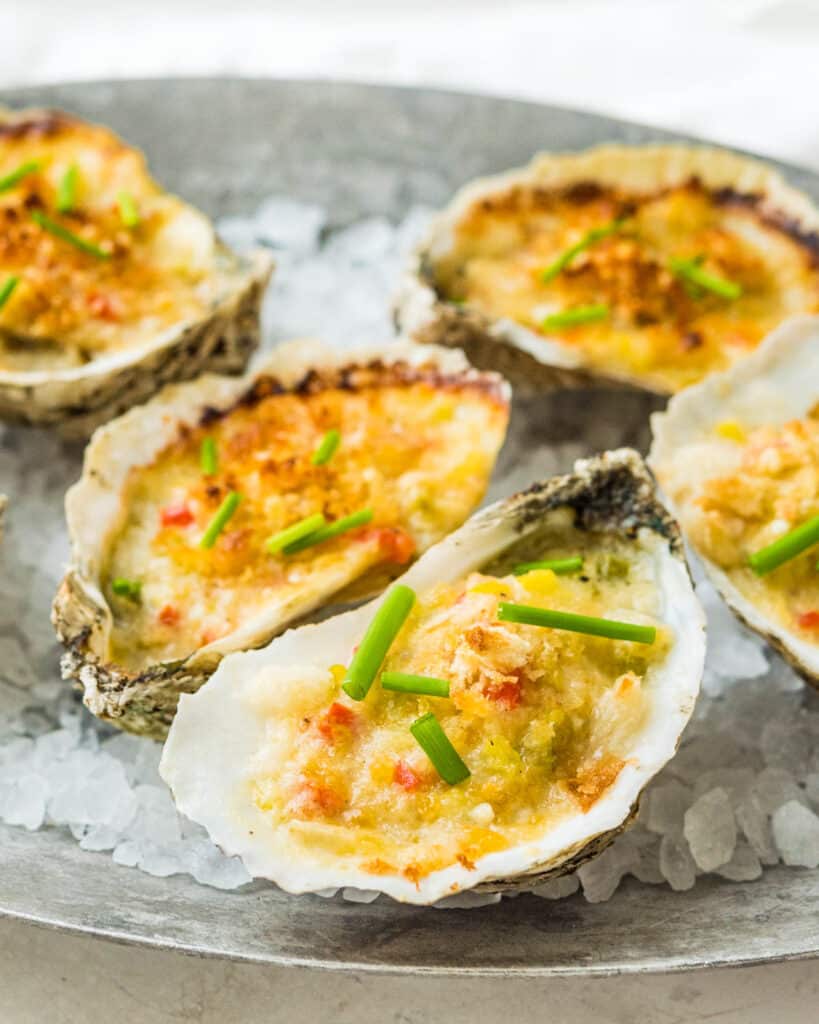 A pewter dish filled with rock salt and topped with baked oysters.