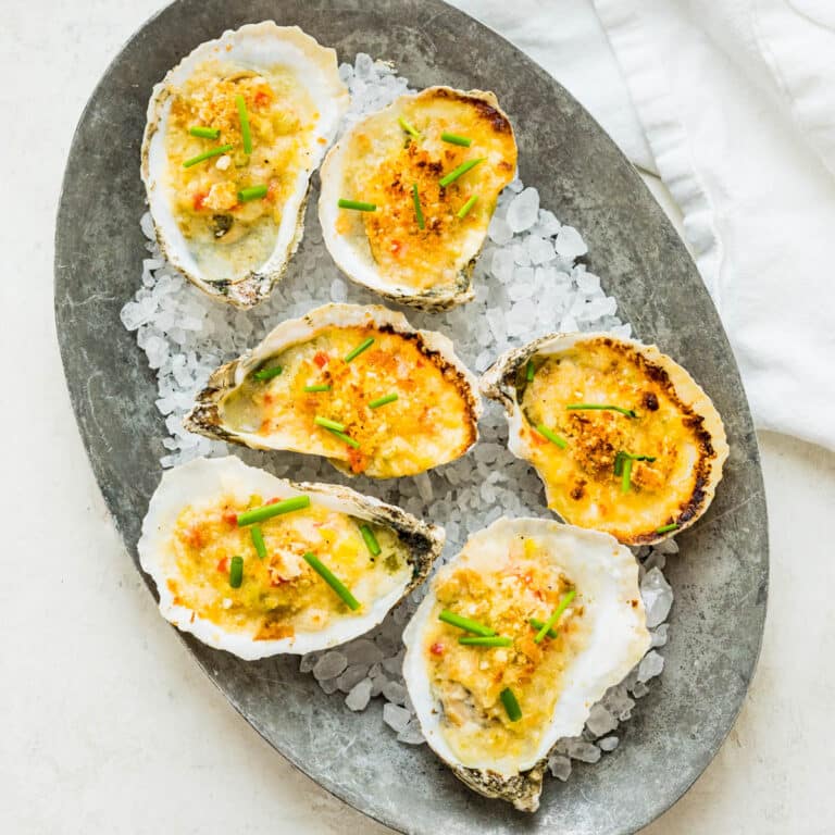 Serving the baked oysters with creamy wine sauce on a bed of rock salt.