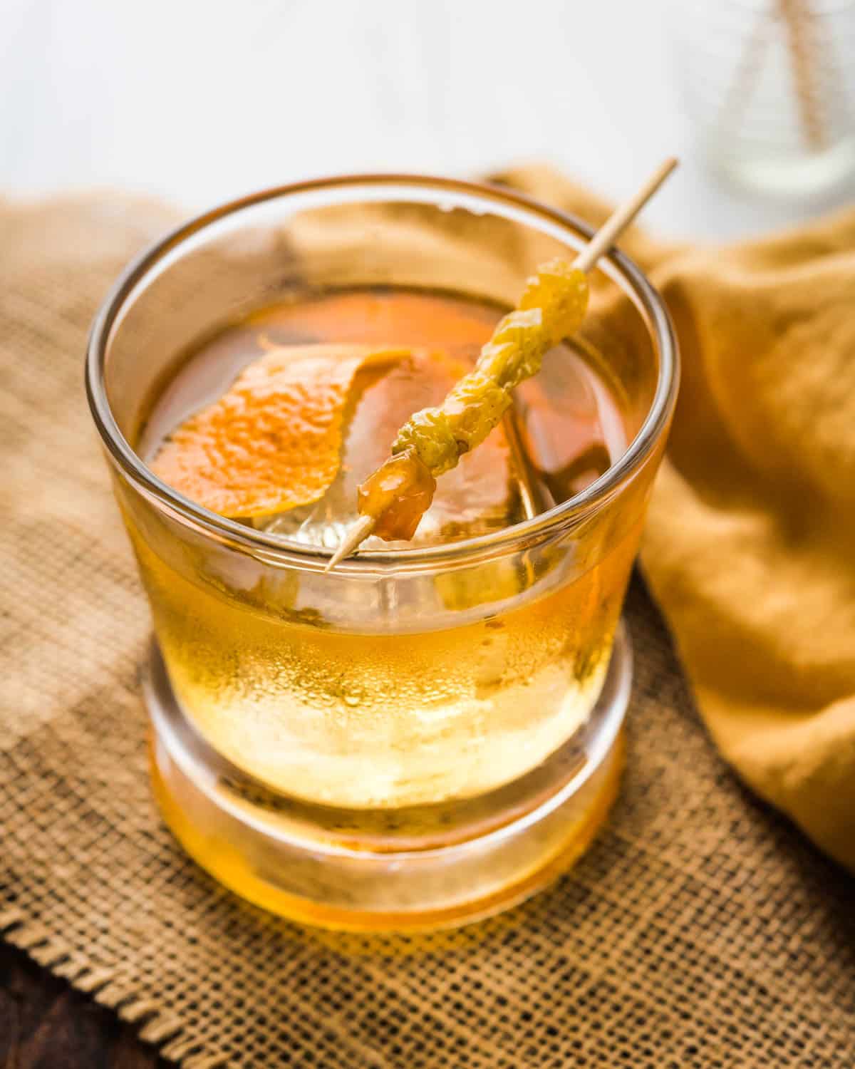 the old fashioned being served with orange peel garnish.