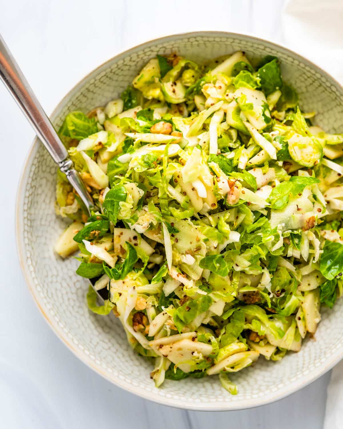 fennel apple brussels sprout slaw in a white bowl.