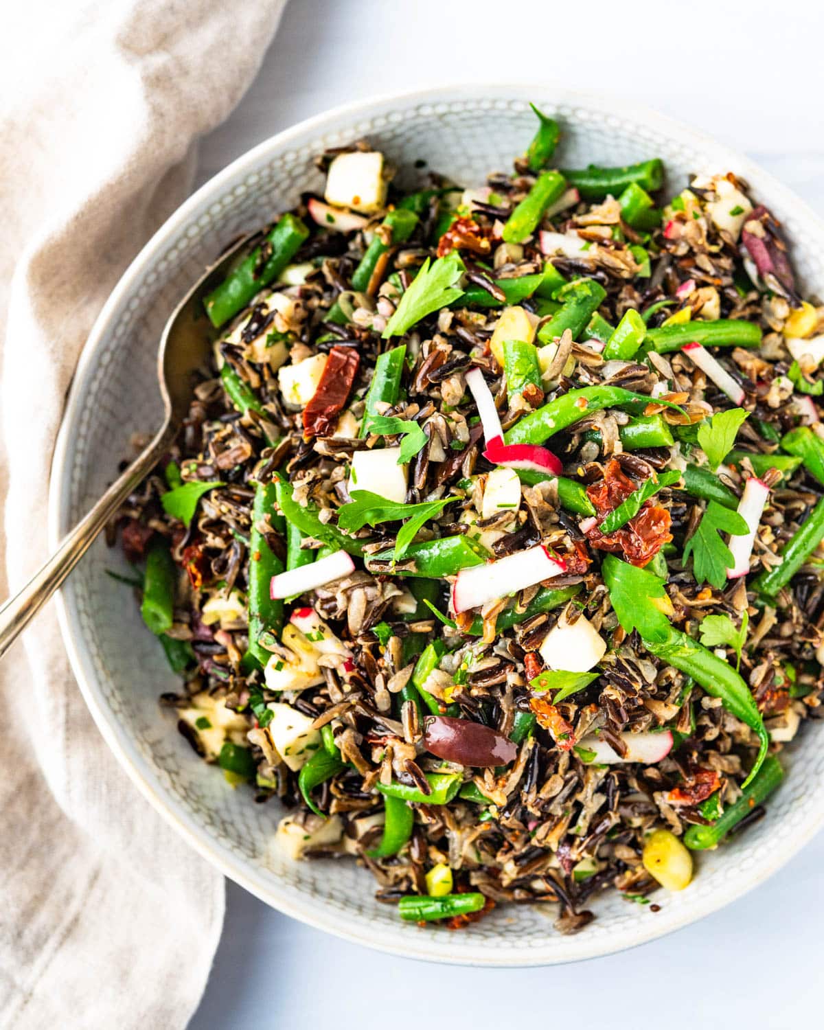 a bowl of healthy wild rice salad with green beans.