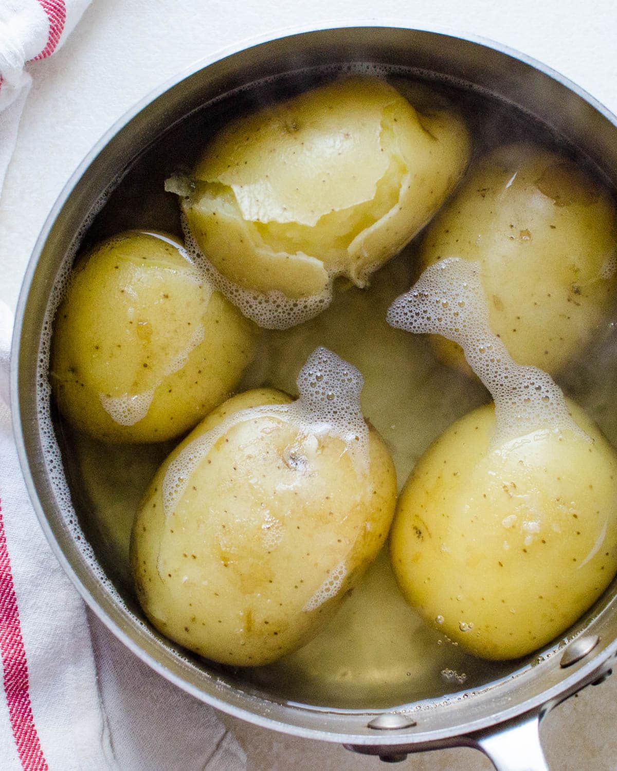 Whole potatoes boiled in a pot.
