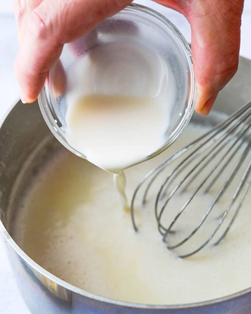 Adding cornstarch slurry to the ice cream base. 