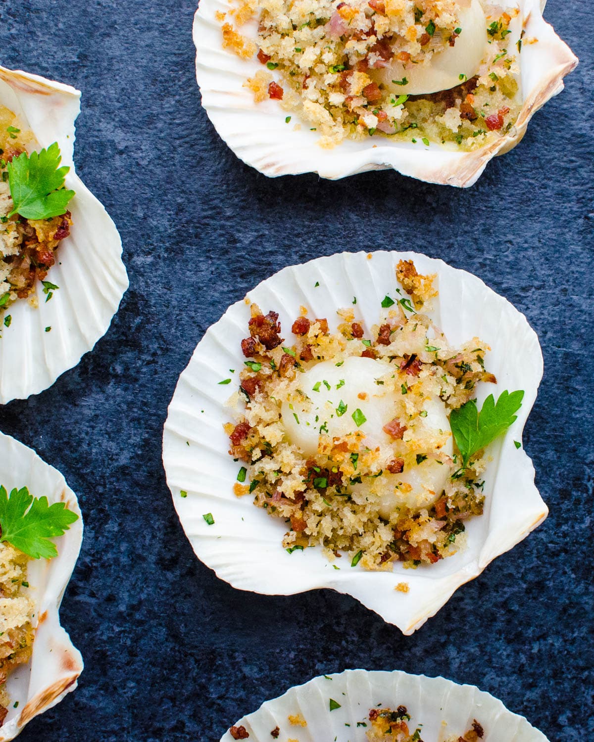A display of baked sea scallops in their shells.