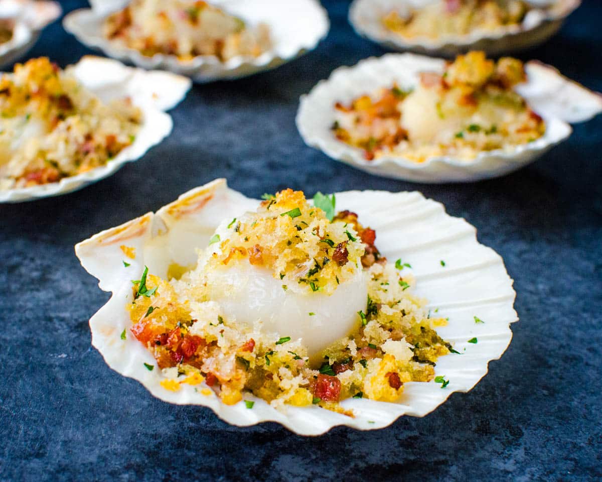 Serving baked sea scallops in their shells.
