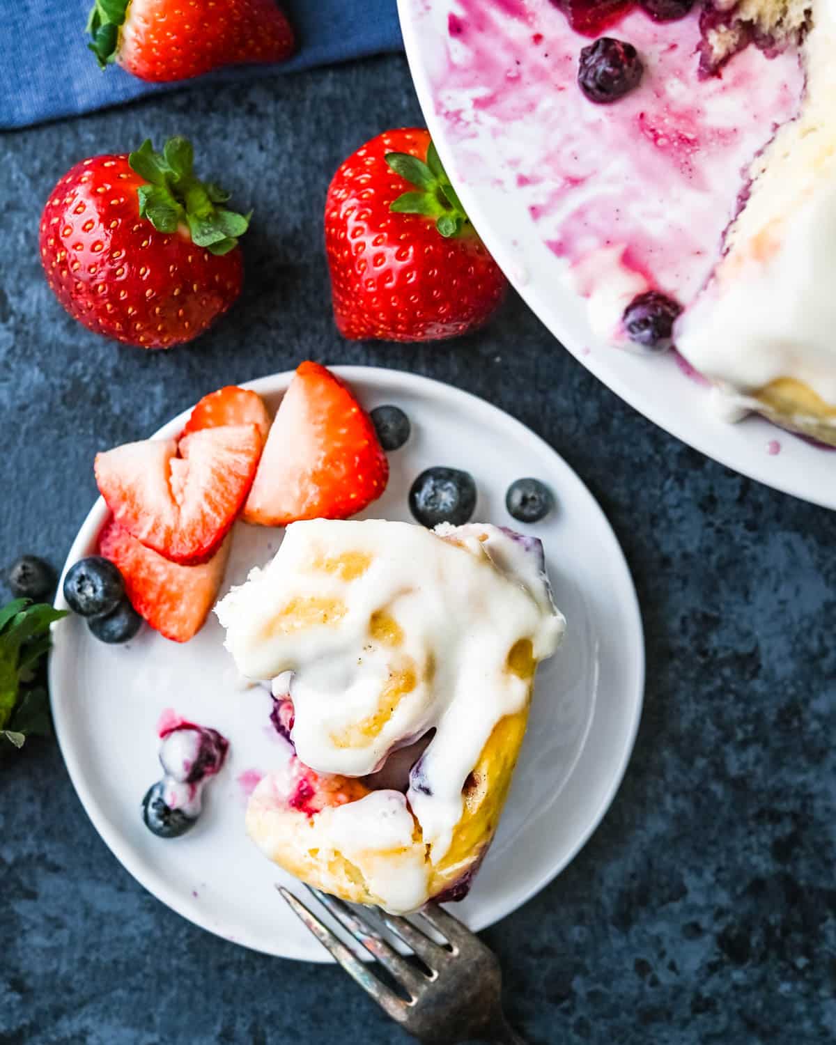 lemon sweet rolls with blueberries and strawberries on the plate.