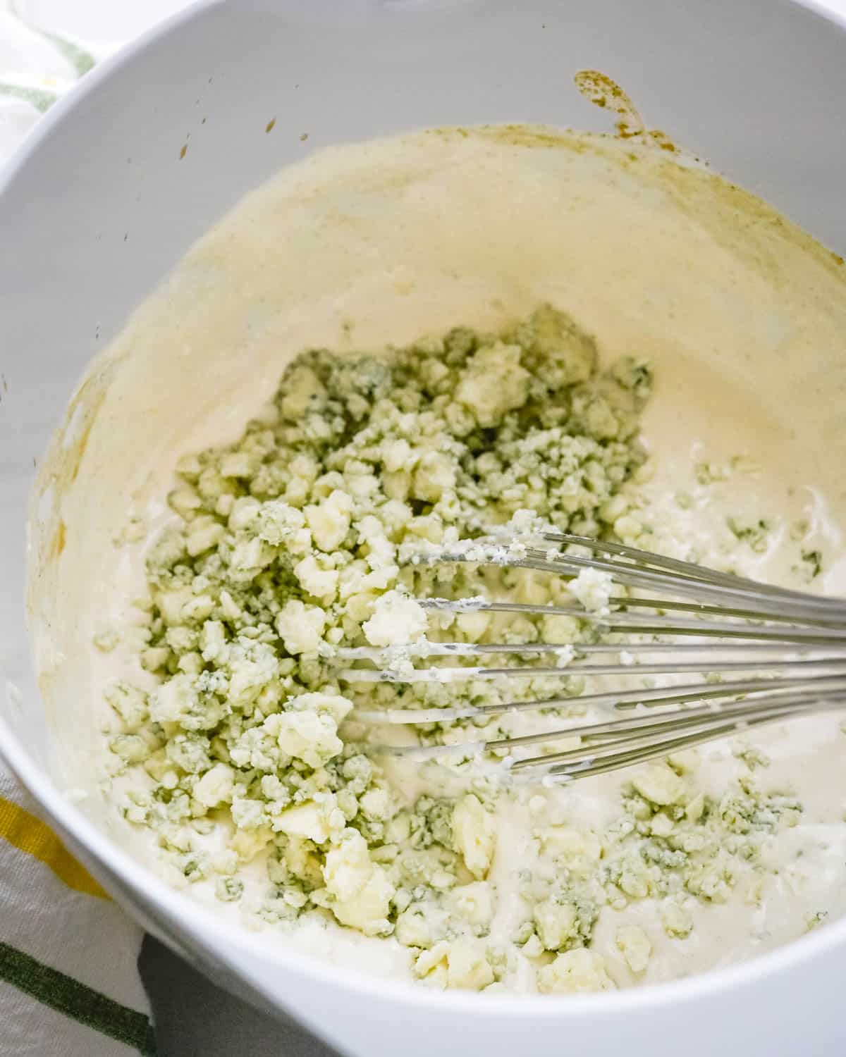 We are adding blue cheese crumbles to the bowl.