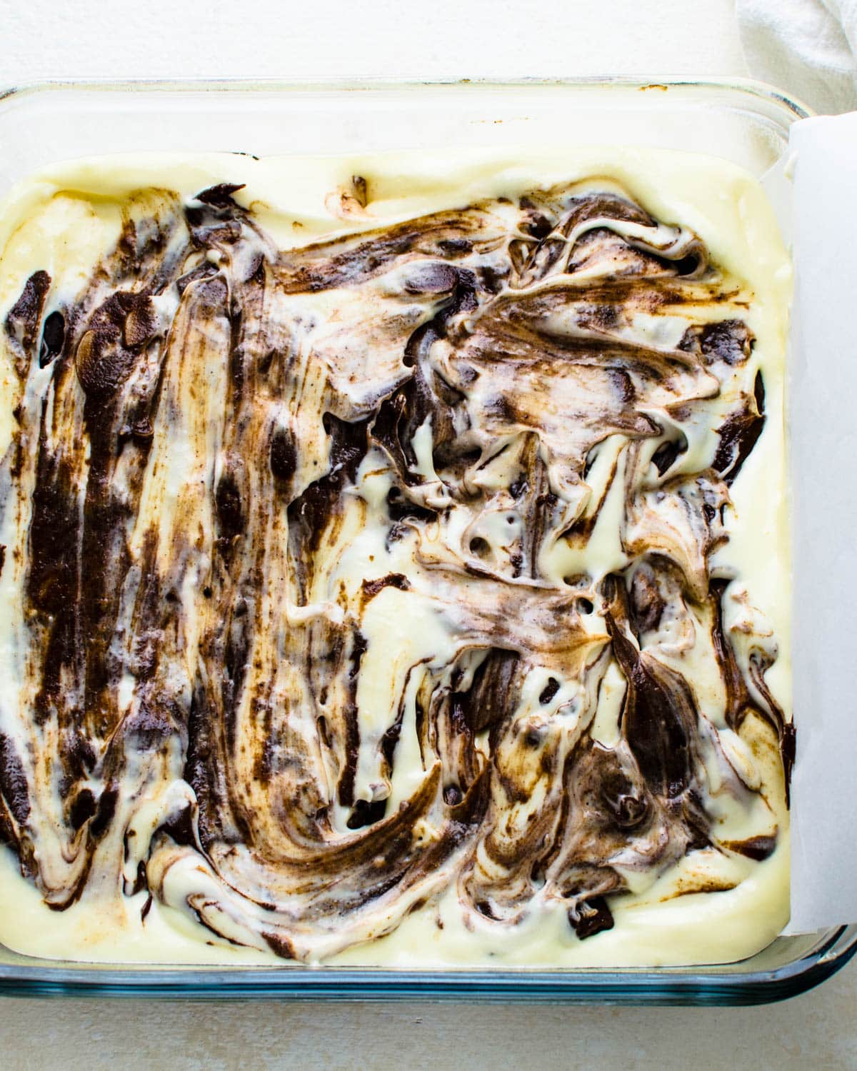 Swirling the remaining brownie batter into the cheesecake layer.