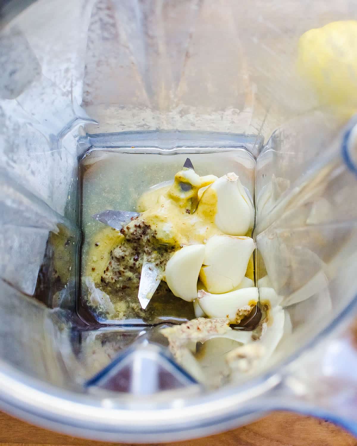 Adding garlic, dijon and vinegar to the blender. 