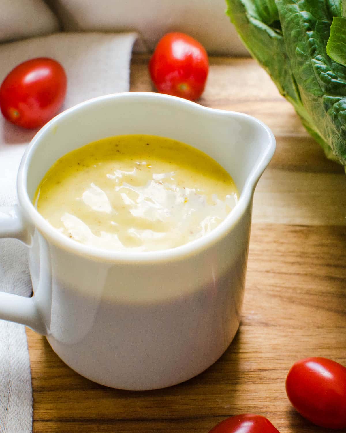 A small pitcher of the Caesar salad dressing recipe.