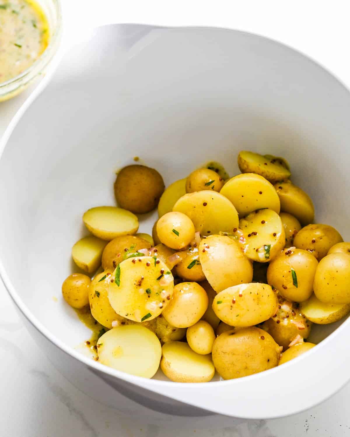 Dressing the hot cooked potatoes with some of the lemon dressing. 
