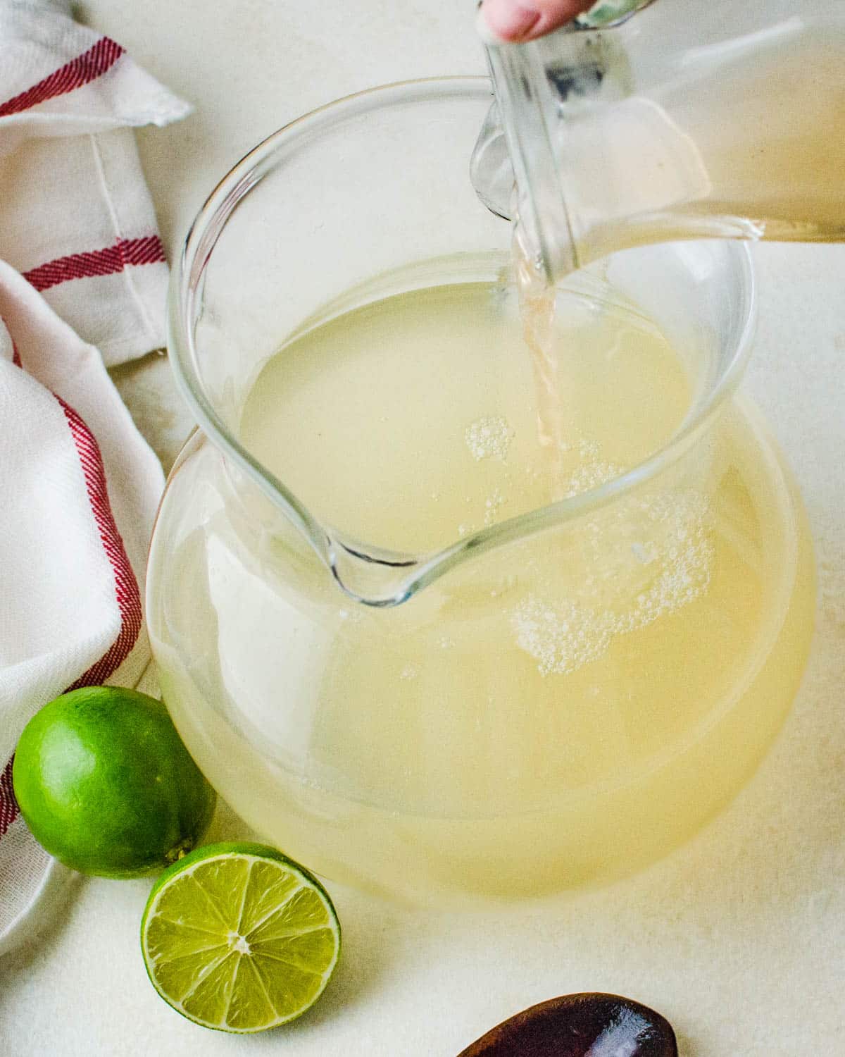 Adding guava simple syrup to the lime mixture.