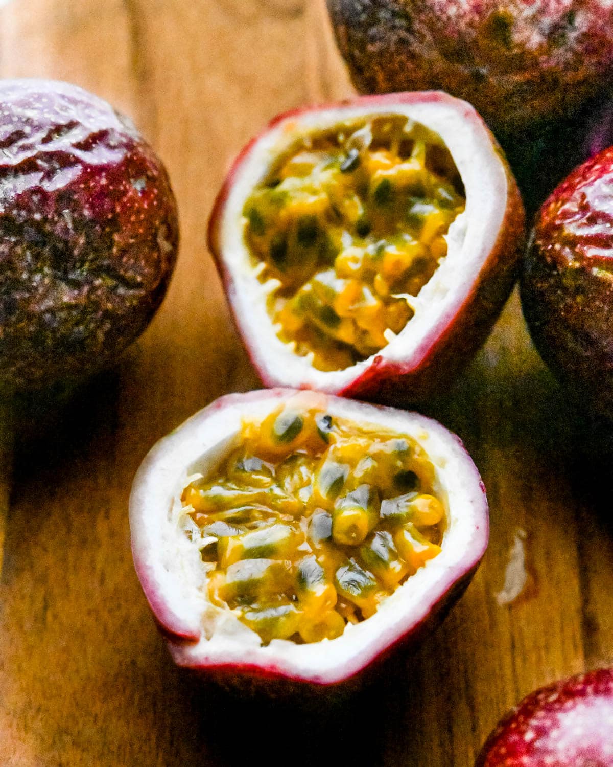 Slicing passion fruit in half to reveal the pulp inside.