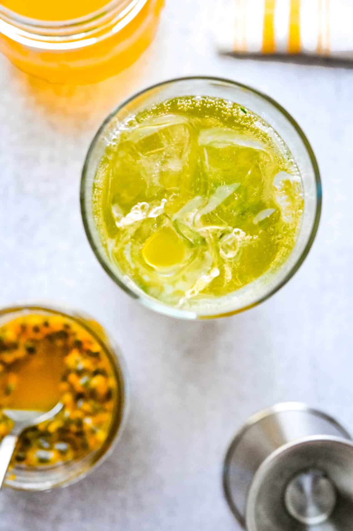 Adding sparkling water to the passion fruit mojito to give it bubbles.