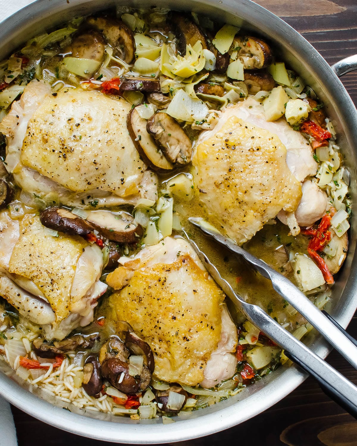 Nestling the par-cooked chicken thighs into the rice and vegetable mixture.