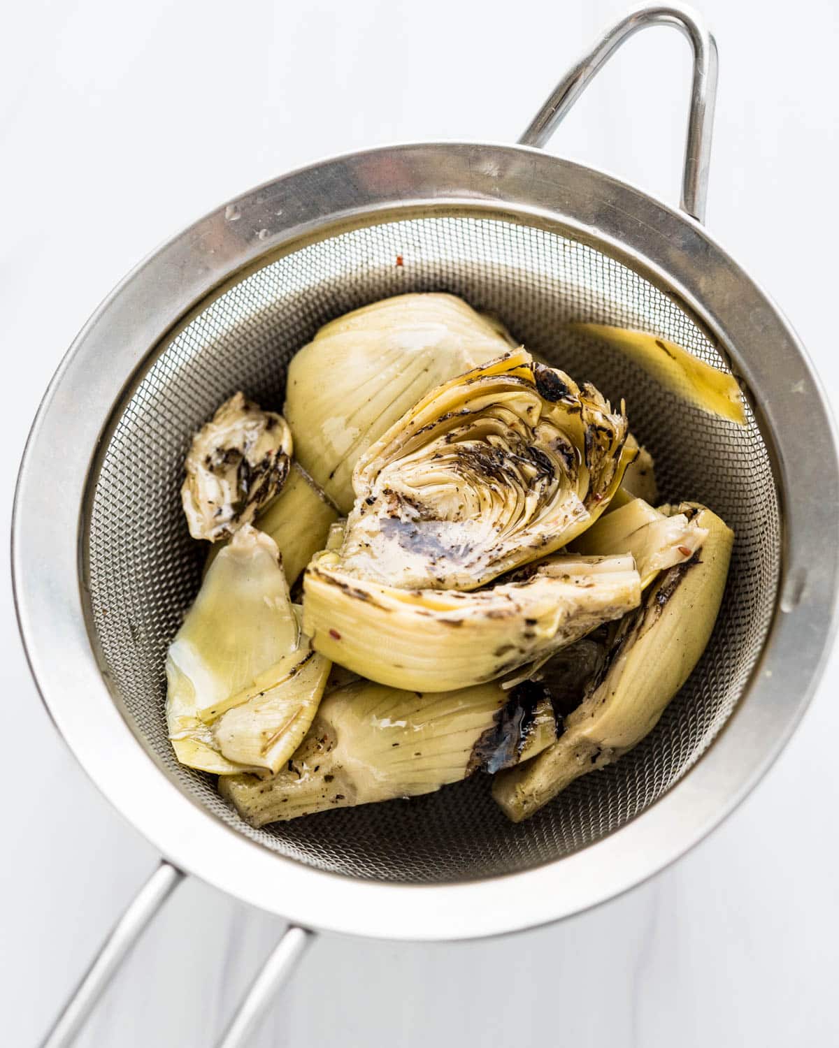 I am draining artichokes in a strainer.