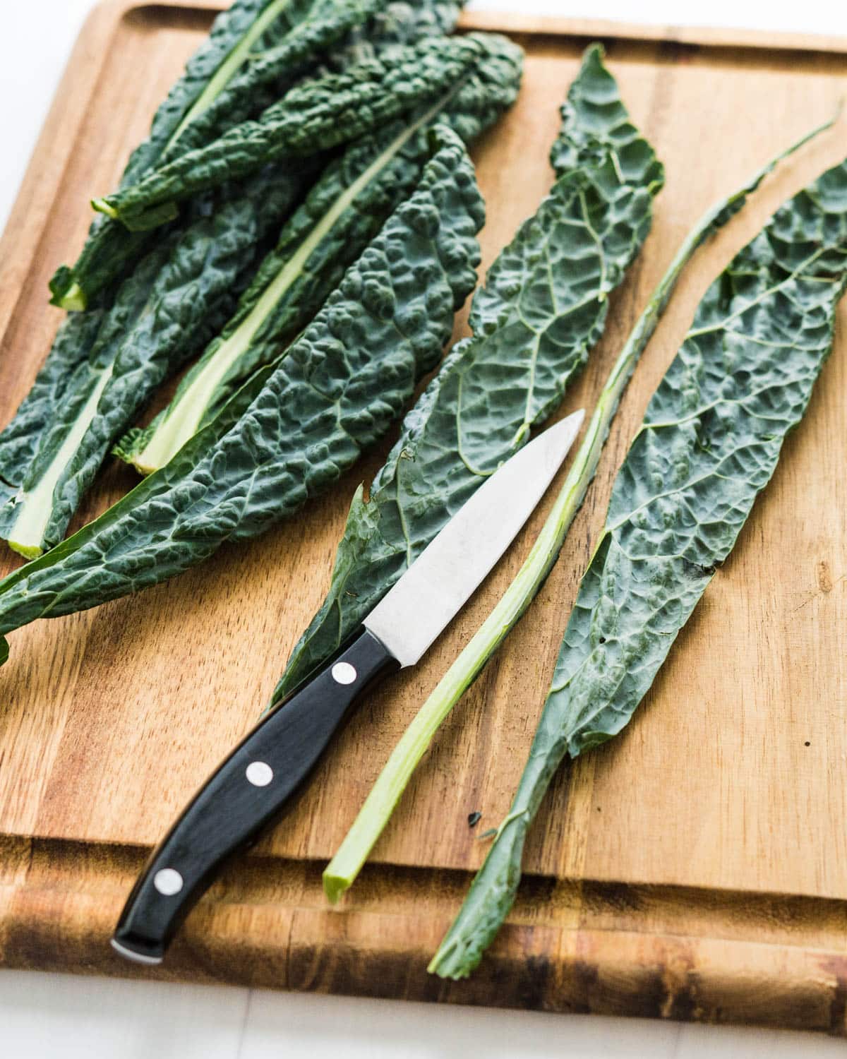 Removing the tough stem from Tuscan kale leaves. 