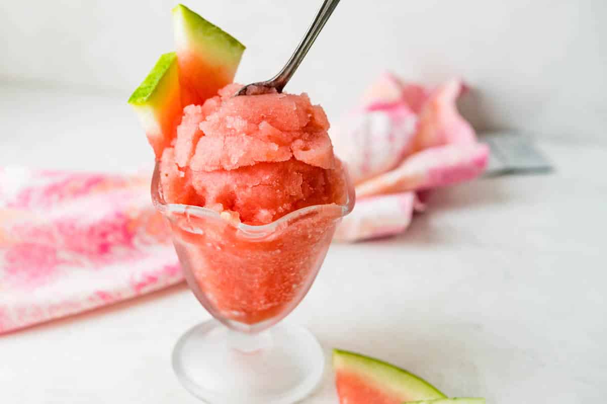 A scoop of the watermelon dessert  with a wedge of fresh melon.