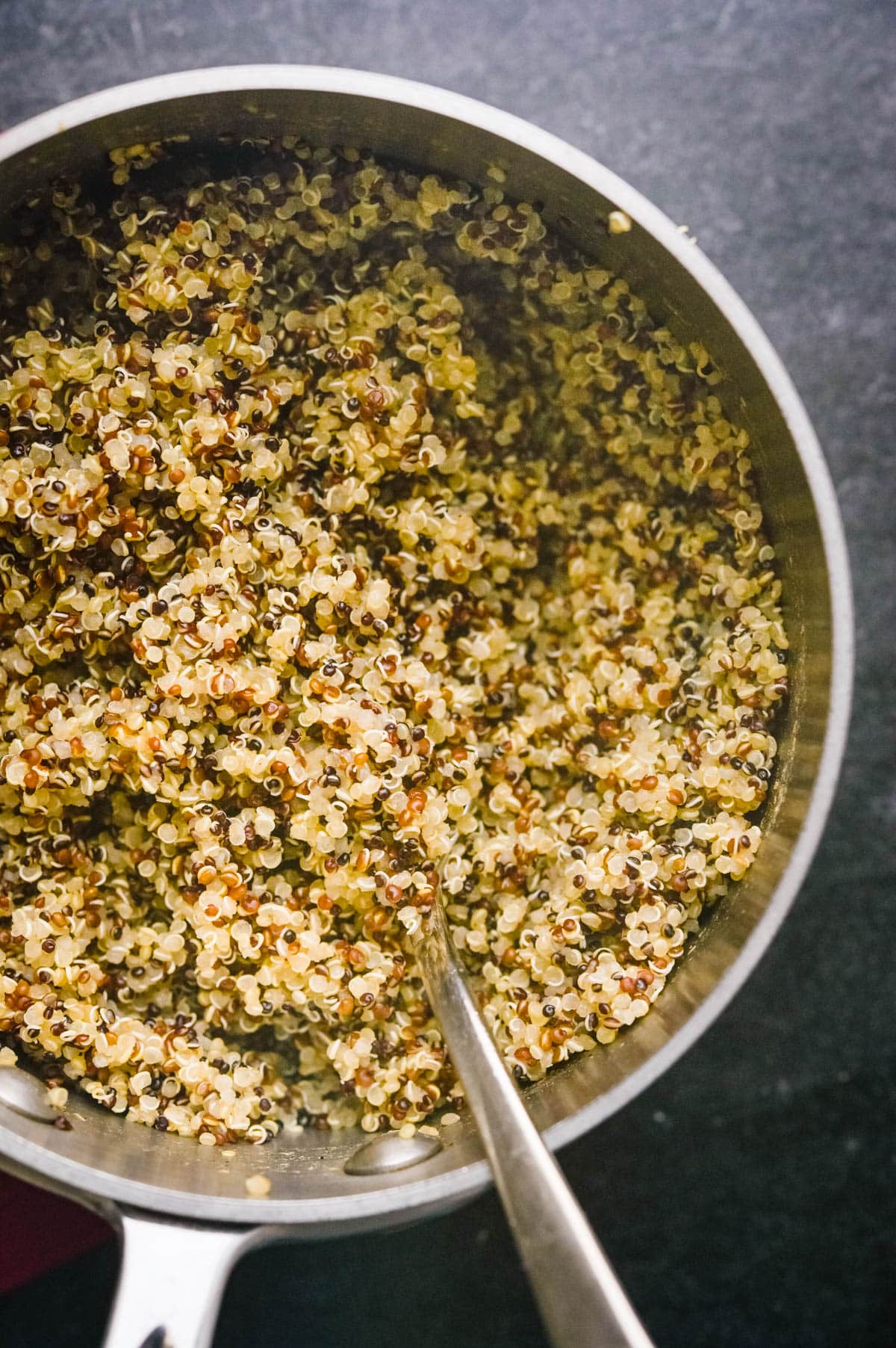 Cooked and fluffed tri-color quinoa in a pot.
