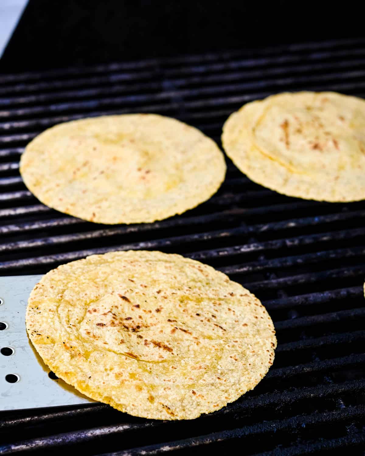 Toasting the corn tortillas on the grill.