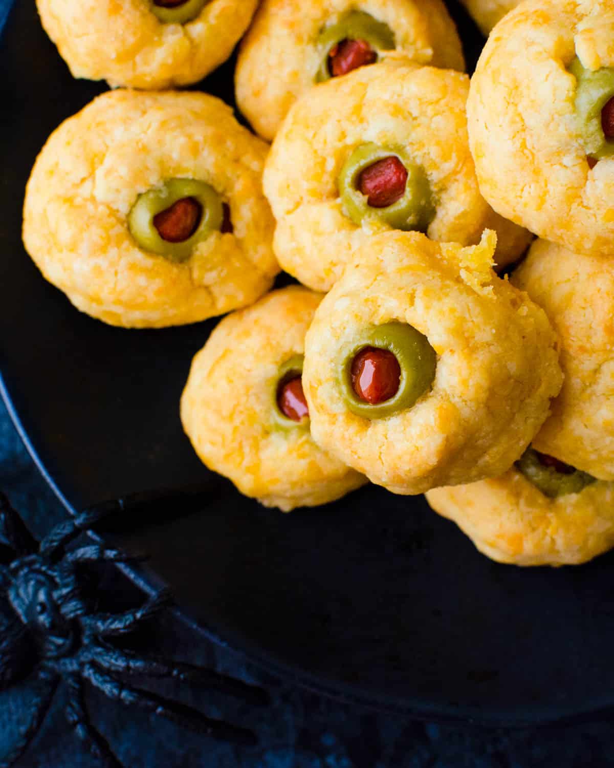 A platter of spooky cheese olive eyeballs for a savory adult appetizer. Perfect for Halloween.