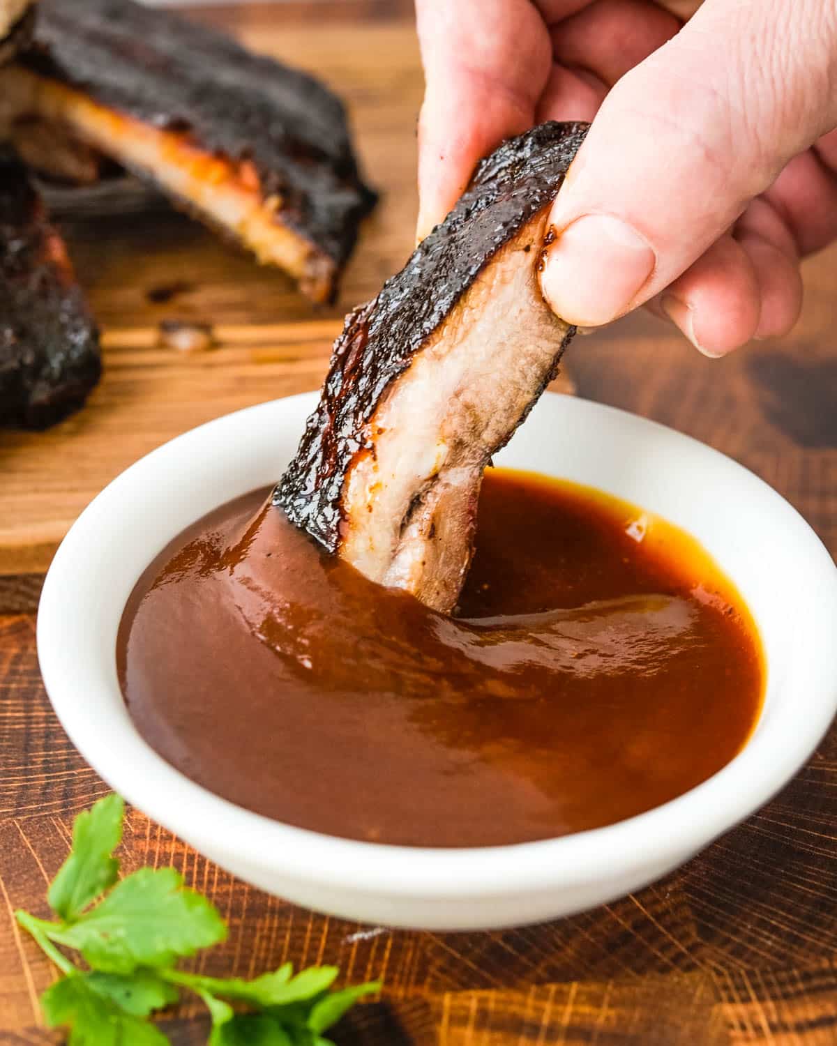 Dipping a rib into bbq sauce.