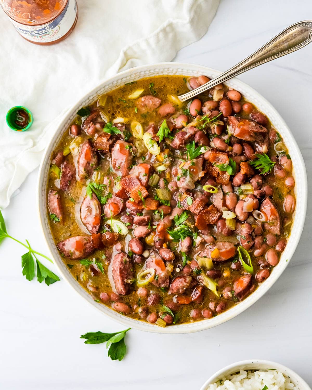 A bowl of red beans and sausage with bacon.