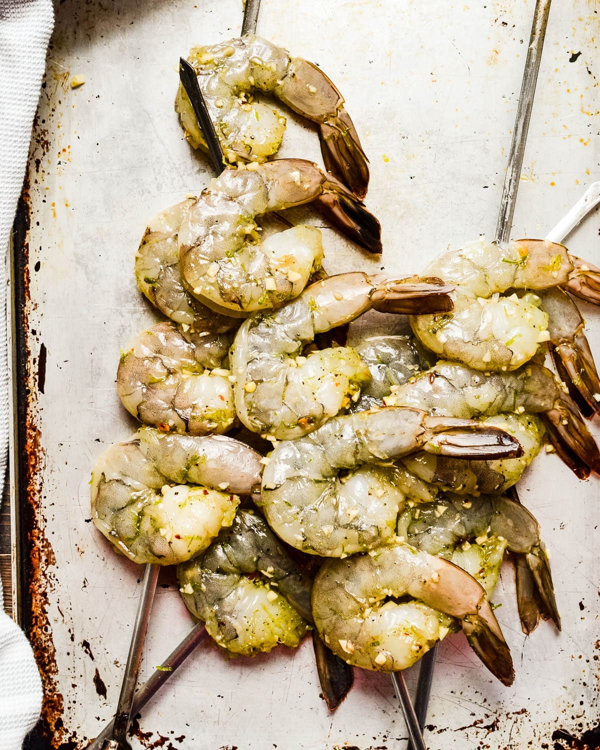 A platter of marinated shrimp on skewers.