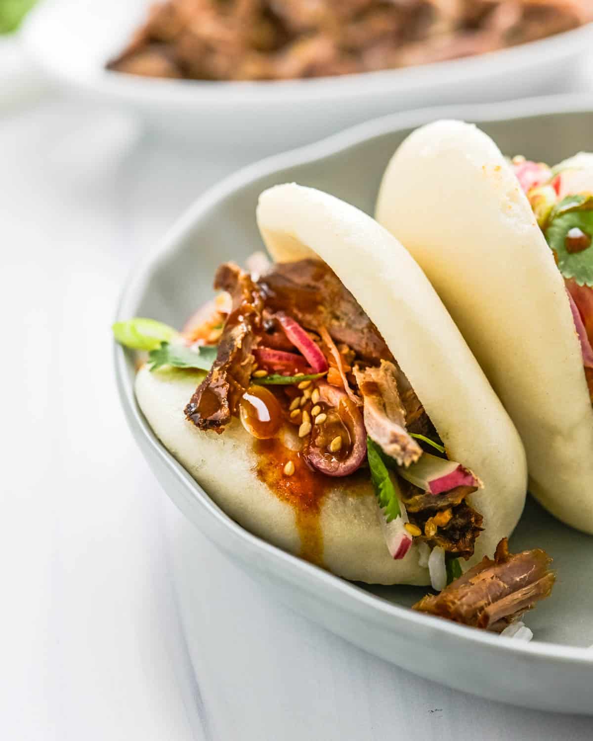 A closeup picture of stuffed Asian buns with BBQ pork.
