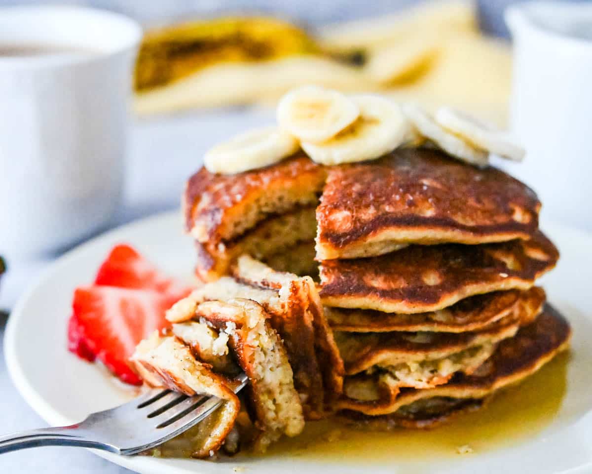 Cutting into a stack of the banana pancakes.