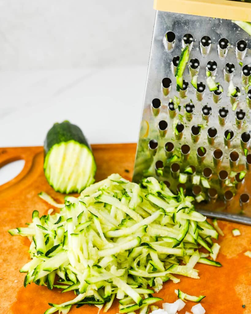 Grating zucchini on a box grater.