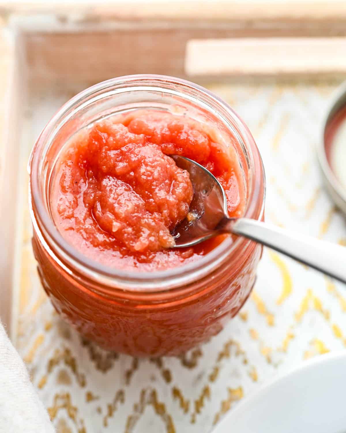 A jar of guava jam with a spoon.