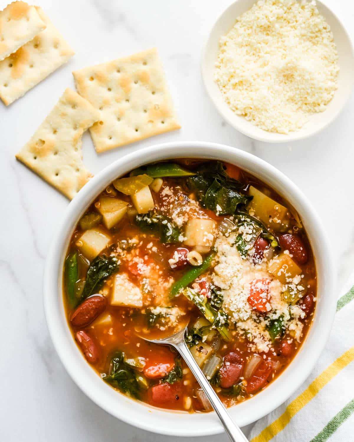 Serving vegetarian minestrone soup with crackers and parmesan.