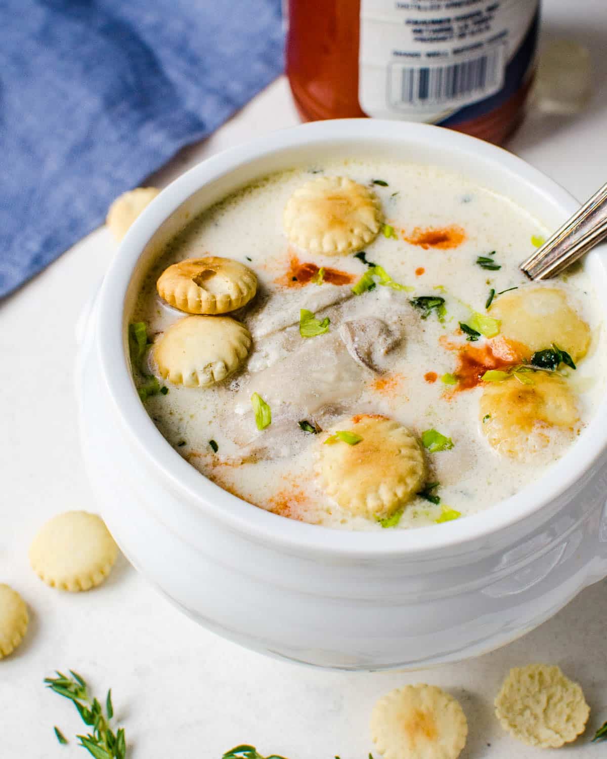 A bowl of hearty oyster stew with hot sauce.