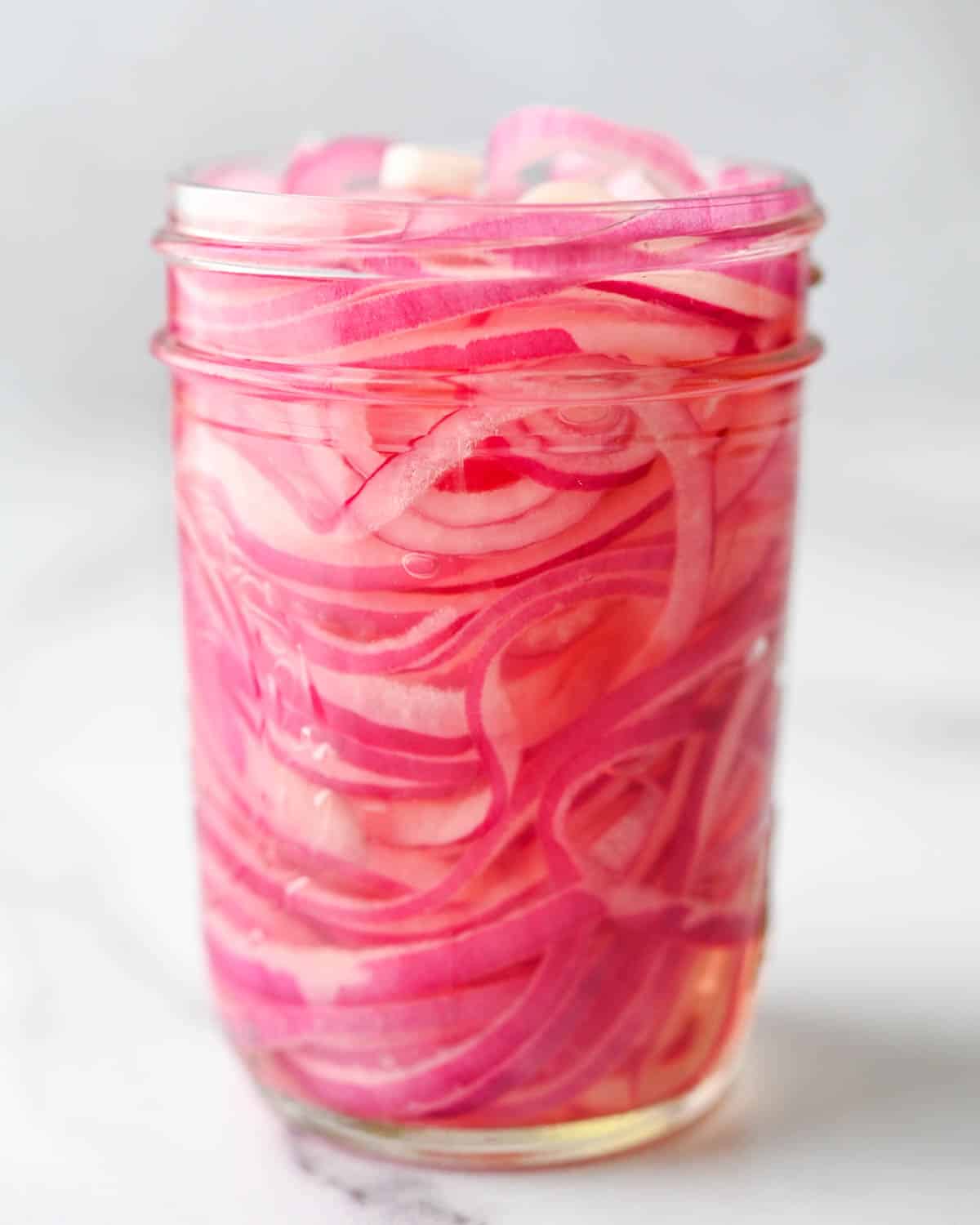 I am seeing the rings of the pink pickled onions in brine through a clear jar.