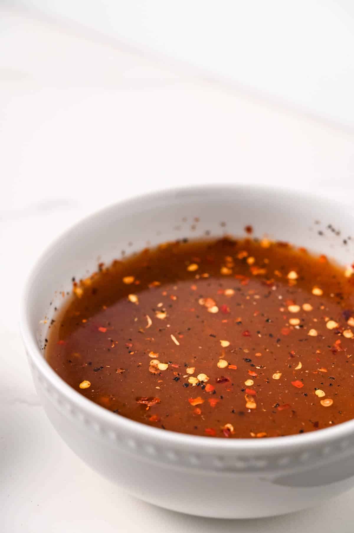 Carolina-style vinegar sauce for pulled pork in a white bowl.