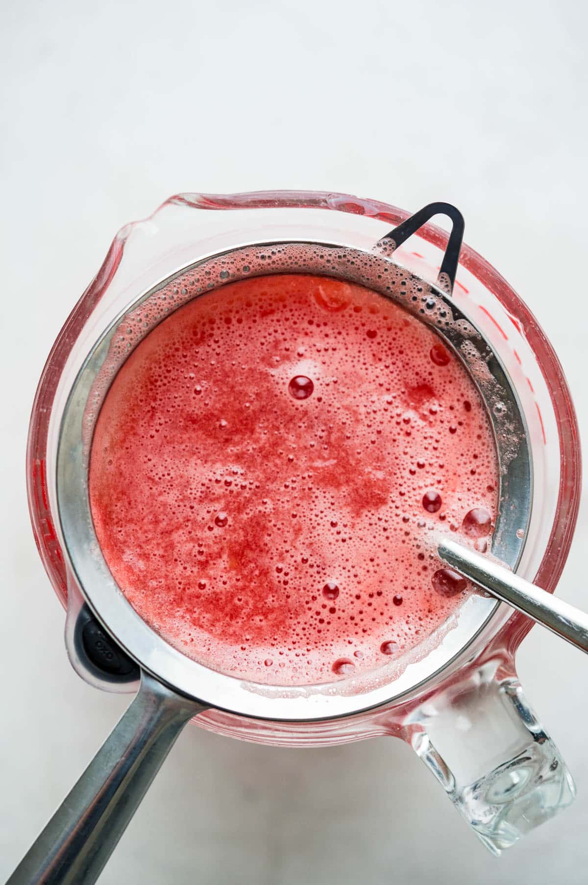 Using a spoon, stir the watermelon juice and pulp so it strains faster.