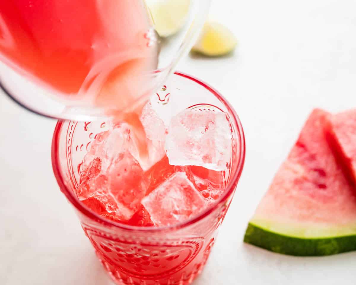 Pouring watermelon fresca over ice.